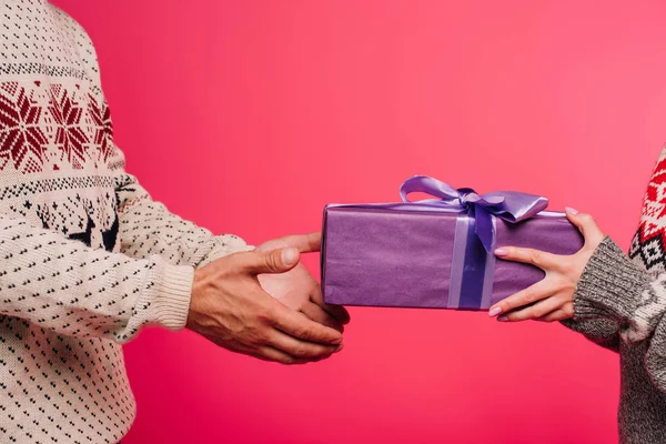 Image recadrée de petite amie présentant cadeau au petit ami isolé sur rose — Photo de stock