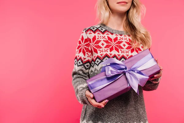 Image recadrée de la femme en pull tenant boîte cadeau violet isolé sur rose — Photo de stock