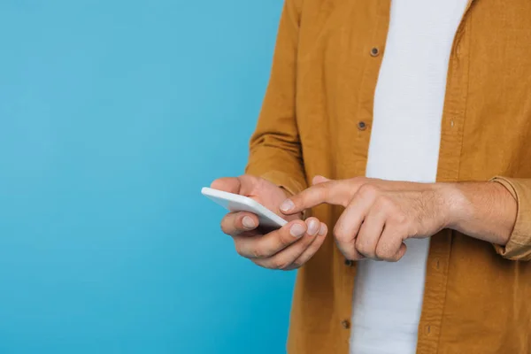 Imagem cortada do homem usando smartphone isolado no azul — Fotografia de Stock