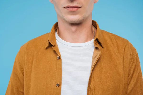 Imagen recortada de hombre de pie en camisa marrón aislado en azul - foto de stock