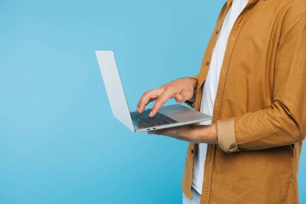 Image recadrée de l'homme en utilisant un ordinateur portable isolé sur bleu — Photo de stock