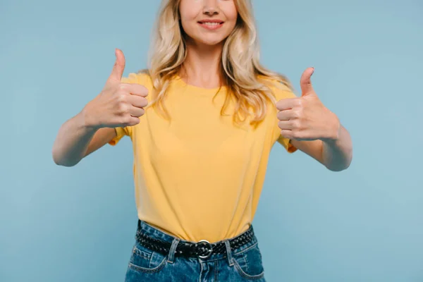Imagem cortada de menina sorridente em camisa e shorts mostrando polegares para cima isolado em azul — Fotografia de Stock