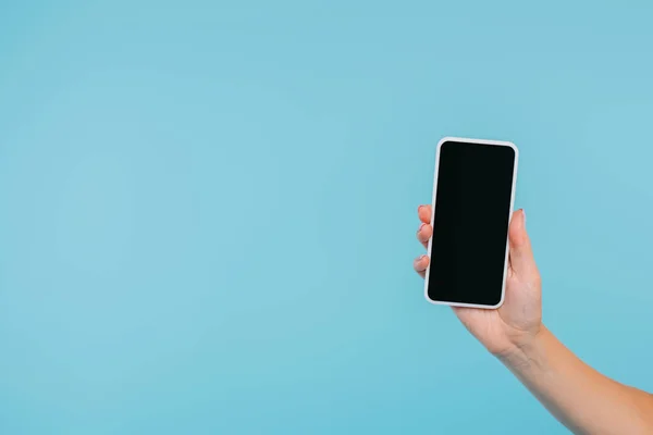 Image recadrée de fille tenant smartphone avec écran blanc à la main isolé sur bleu — Photo de stock