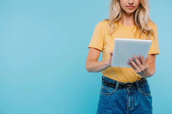 Cropped image of girl in shirt and shorts using tablet isolated on blue — Stock Photo