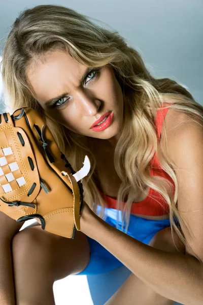 Retrato de cerca de una mujer joven con guante de béisbol mirando a la cámara - foto de stock