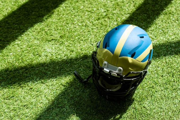 Visão de alto ângulo do capacete de futebol americano na grama verde — Fotografia de Stock