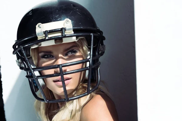 Close-up retrato de jovem mulher em sutiã esporte e capacete de futebol americano em branco — Fotografia de Stock