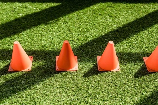 High angle view of row of safety cones standing on grass field — Stock Photo
