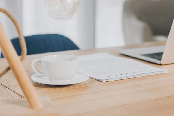 Ordinateur portable, documents et tasse de thé sur une table en bois au bureau — Photo de stock