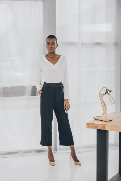 Fashionable attractive african american businesswoman looking at camera in office — Stock Photo