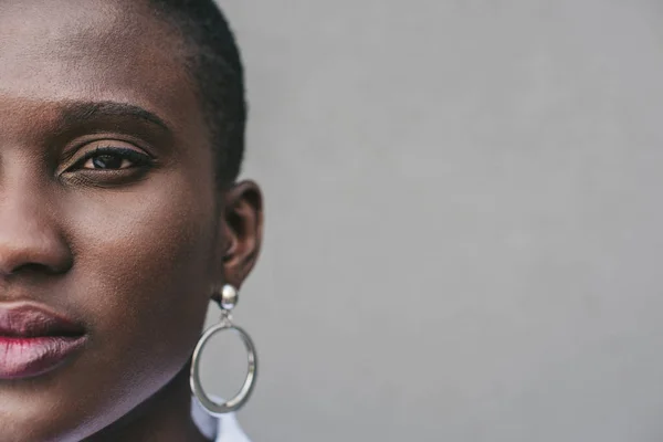 Imagem cortada de mulher americana africana atraente elegante perto da parede cinza — Fotografia de Stock