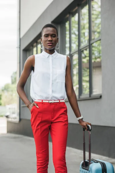 Elegante atraente mulher de negócios afro-americana de pé com saco de viagem na rua — Fotografia de Stock