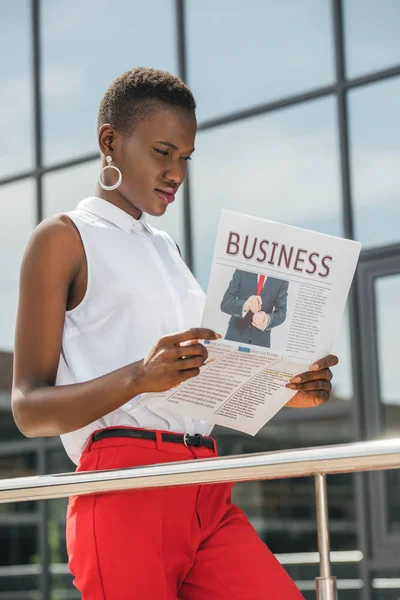 Stylische schöne afrikanisch-amerikanische Geschäftsfrau liest Zeitung in der Nähe von Business Center — Stockfoto