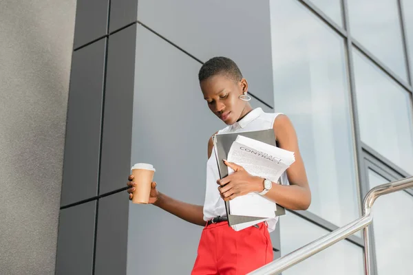 Vue à angle bas de femme d'affaires afro-américaine attrayante élégante regardant vers le bas sur les escaliers dans la rue — Photo de stock