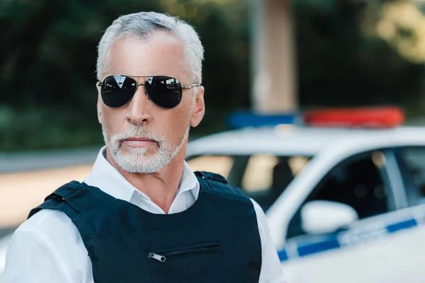 Close up portrait of mature policeman in sunglasses looking at camera — Stock Photo