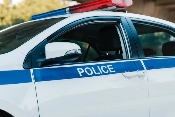 Close up view of automobile with flasher and lettering police at city street — Stock Photo