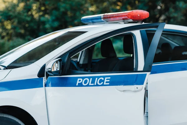 Enfoque selectivo de automóvil con flasher y letras de la policía en la calle de la ciudad - foto de stock