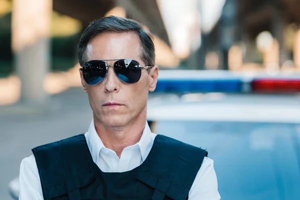 Close up portrait of mature policeman in sunglasses looking at camera — Stock Photo