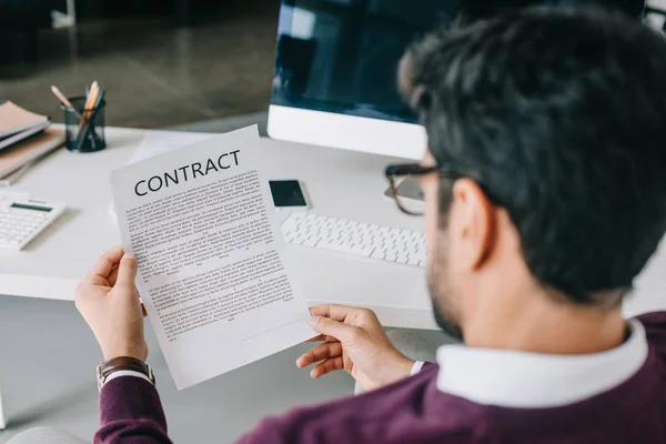 Back view of businessman reading contract in office — Stock Photo