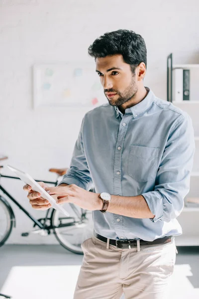 Handsome architect using tablet in office and looking away — Stock Photo