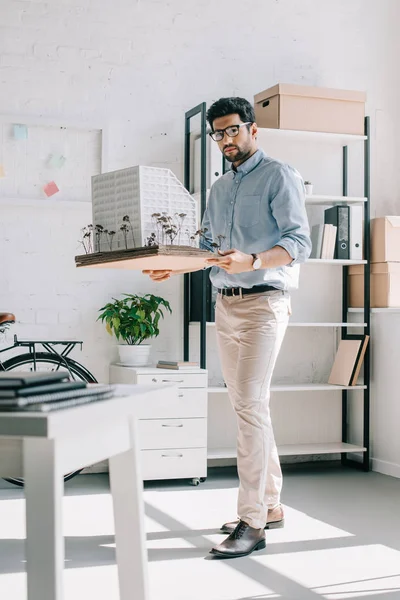 Handsome architect holding architecture model in office — Stock Photo