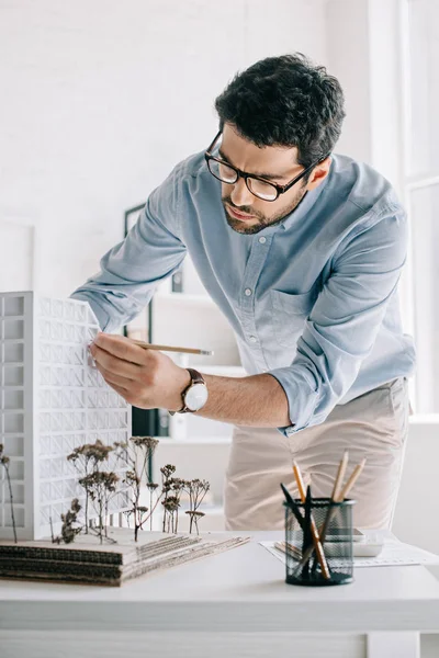 Gutaussehender Architekt arbeitet mit Architekturmodell auf dem Tisch im Büro — Stockfoto