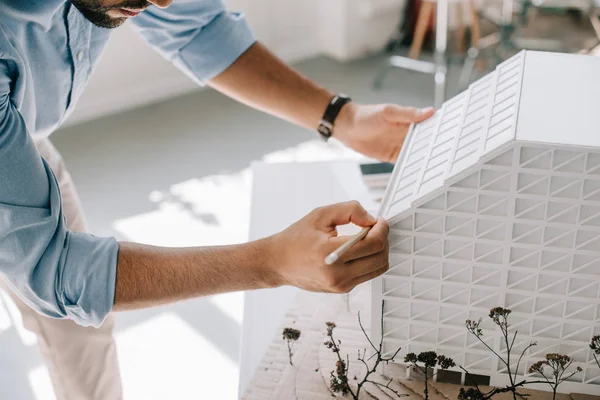 Geschnittenes Bild eines Architekten, der mit einem Architekturmodell auf dem Tisch im Büro arbeitet — Stockfoto