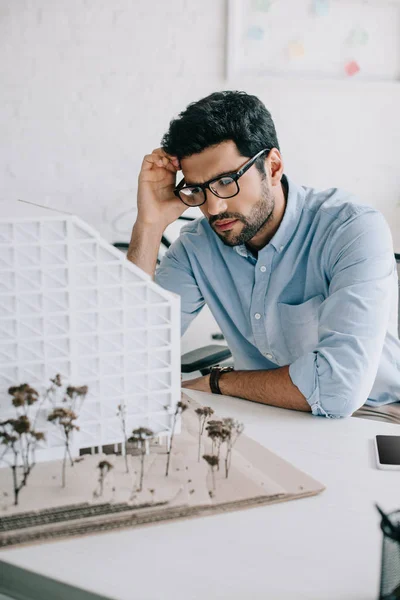 Sconvolto architetto guardando modello di architettura in ufficio — Foto stock