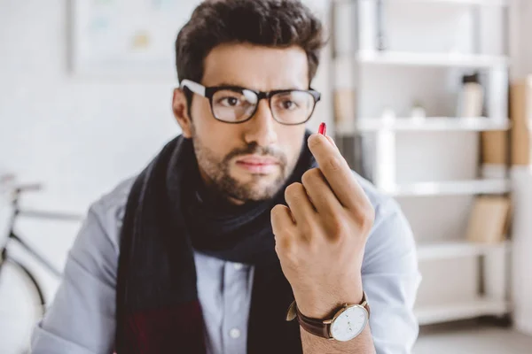 Sick manager in scarf looking at pill in office — Stock Photo