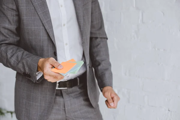 Обрізане зображення бізнесмена, що тримає паперові наклейки в офісі — стокове фото