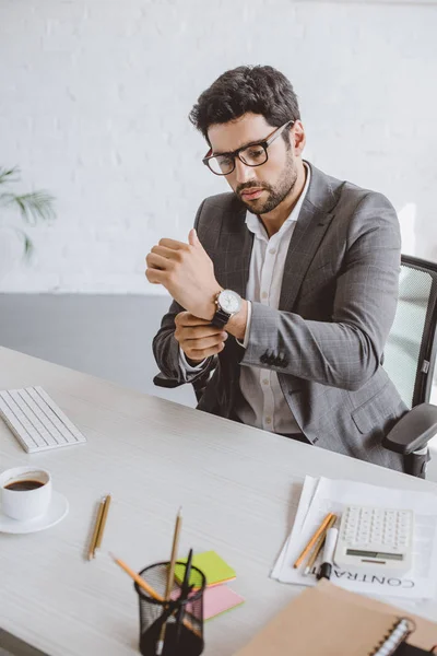 Красивий бізнесмен носить наручний годинник в офісі — стокове фото