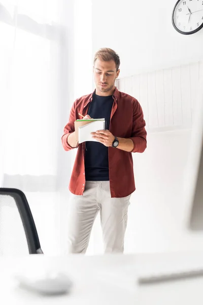 Homem de negócios escrevendo em notebook no escritório moderno — Fotografia de Stock