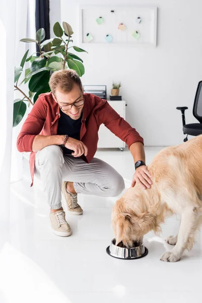 Mann füttert und streichelt Golden Retriever-Hund — Stockfoto