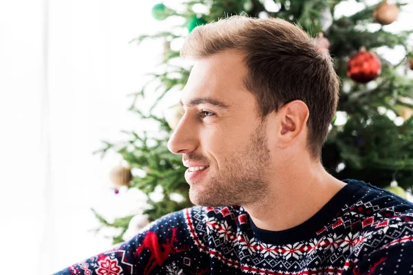 Homem bonito em camisola de Natal olhando para longe — Fotografia de Stock