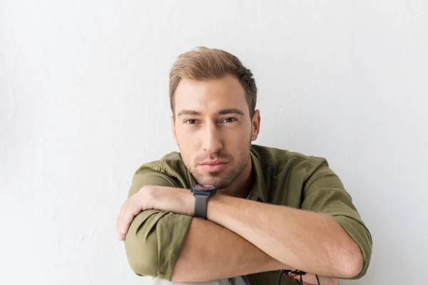 Casual man and looking at camera against white wall — Stock Photo