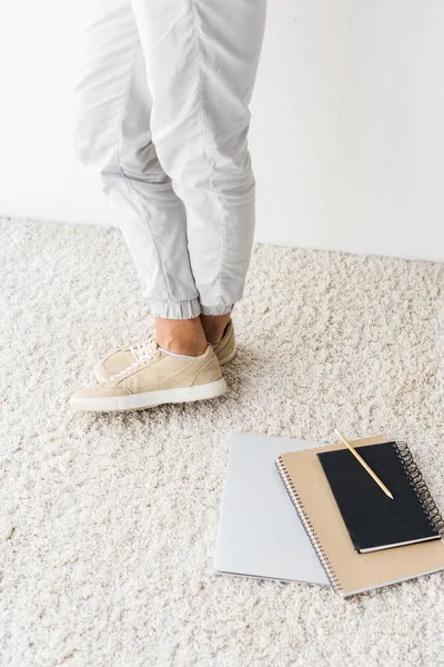 Vista de sección baja de hombre casual y portátil en alfombra beige - foto de stock