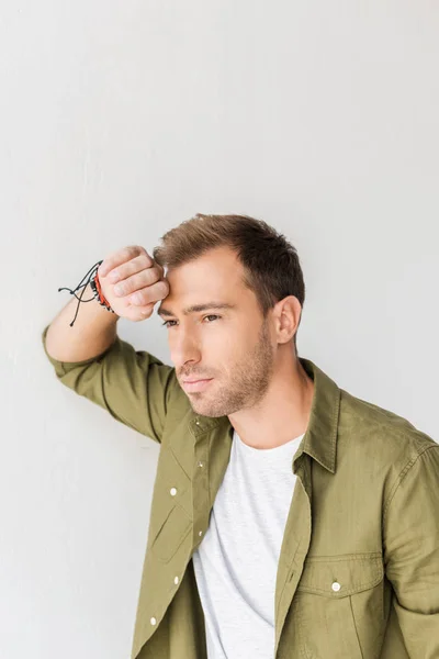 Hombre pensativo contra la pared blanca — Stock Photo