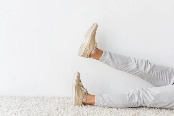 Vue de la section basse de l'homme décontracté sur tapis beige — Photo de stock