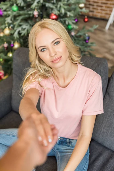 Ritagliato colpo di giovane donna che tiene la mano sul fidanzato e guardando la fotocamera — Foto stock