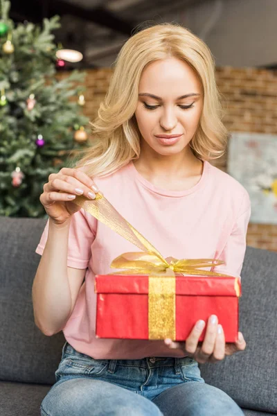 Красива молода жінка відкриває подарункову коробку в різдвяний час — стокове фото
