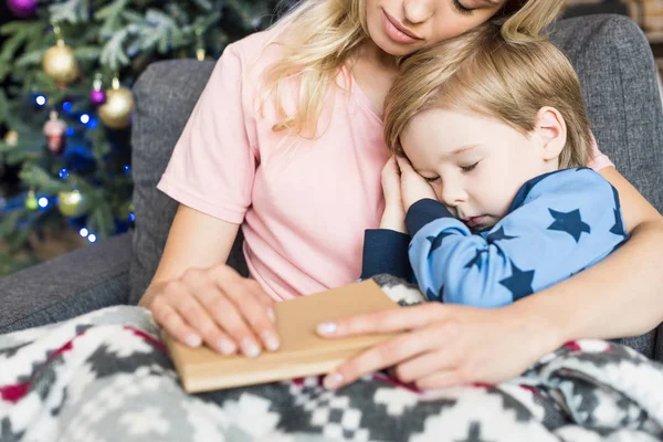 Plan recadré de mère et petit fils dormant dans le canapé à la période de Noël — Photo de stock