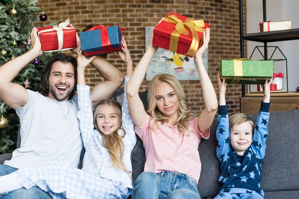 Schöne glückliche Familie mit Weihnachtsgeschenken und lächelnd in die Kamera — Stockfoto