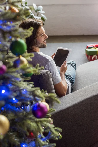 Heureux jeune homme en utilisant tablette numérique avec écran vierge à Noël — Photo de stock