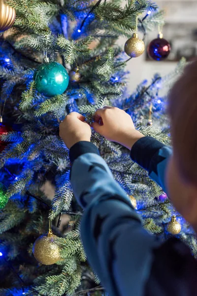 Enfoque selectivo del niño en pijama decorando el árbol de Navidad - foto de stock