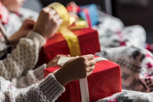 Recortado disparo de joven pareja en invierno suéteres apertura navidad regalos - foto de stock
