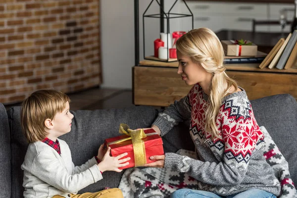 Side view of mother presenting christmas gift to little son — Stock Photo