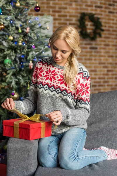 Красива молода жінка взимку светр відкриває різдвяний подарунок вдома — стокове фото