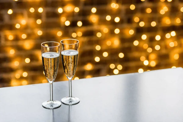 Close-up view of two glasses of champagne and beautiful christmas background — Stock Photo