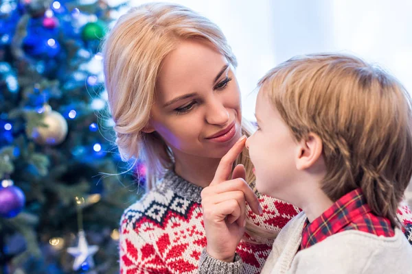 Bela feliz jovem mãe olhando para adorável pequeno filho na época do Natal — Fotografia de Stock