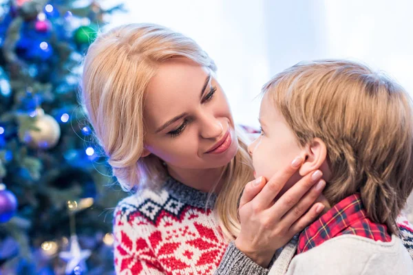 Bela jovem mãe olhando para adorável pequeno filho na época do Natal — Fotografia de Stock